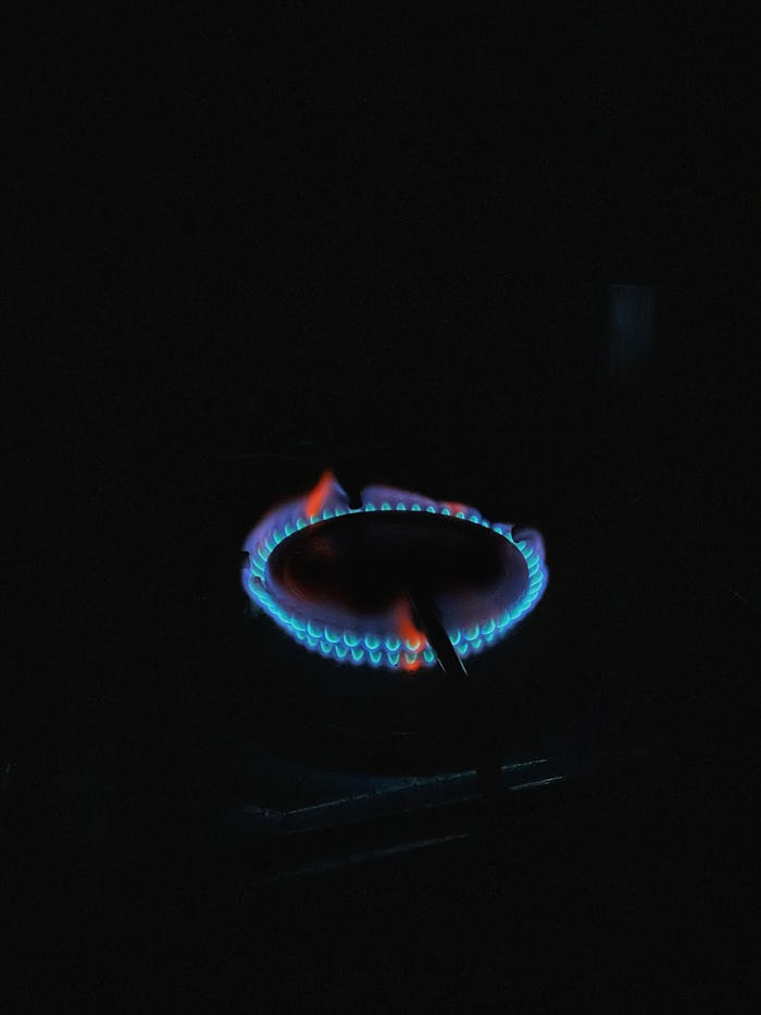 heros-img Vibrant blue gas flame on a stove burner, showcasing energy and heat.